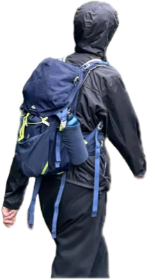 Hiking in the rain in a hooded jacket, carrying a navy backpack